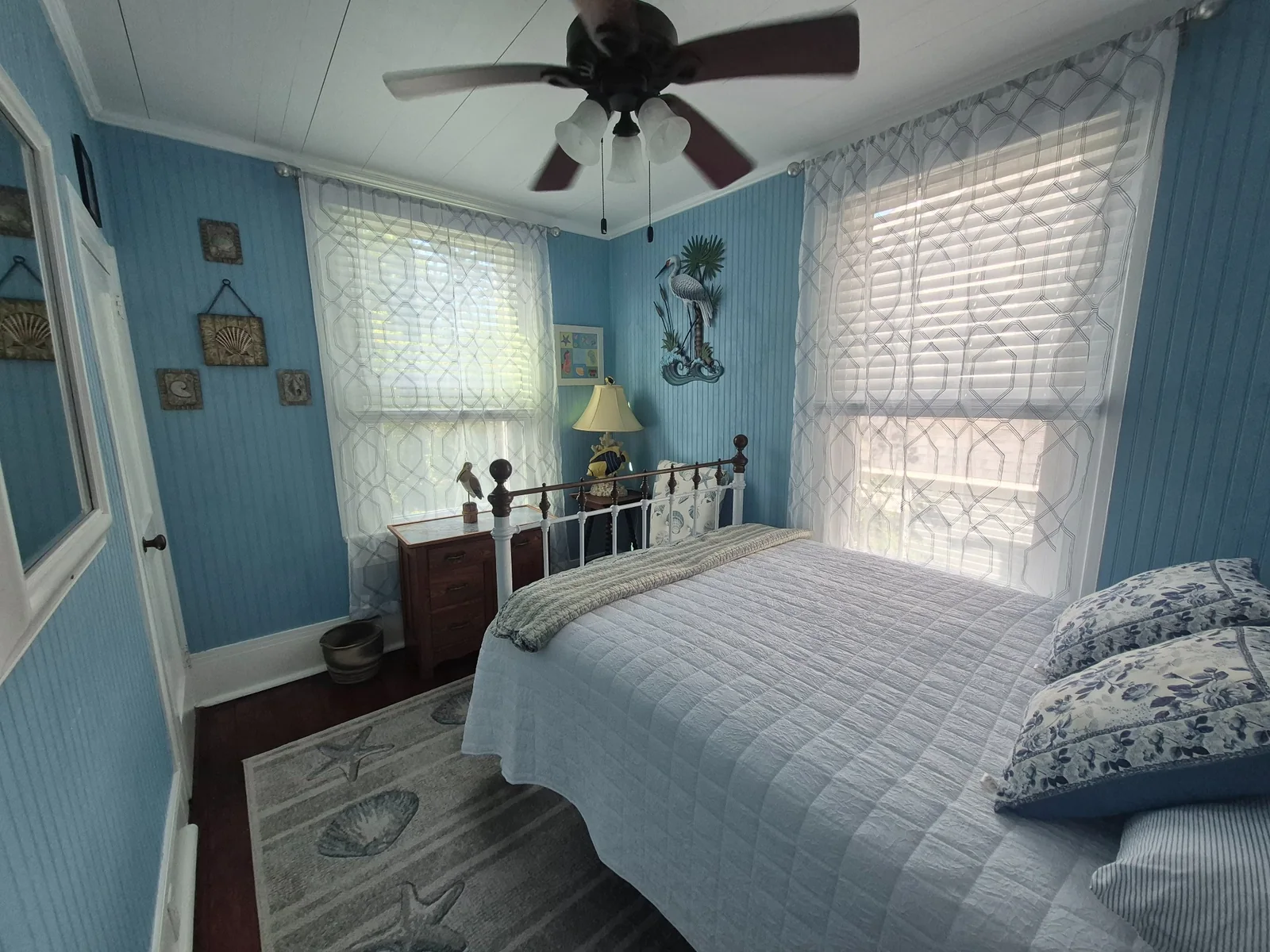 Bright coastal bedroom with blue walls and natural light