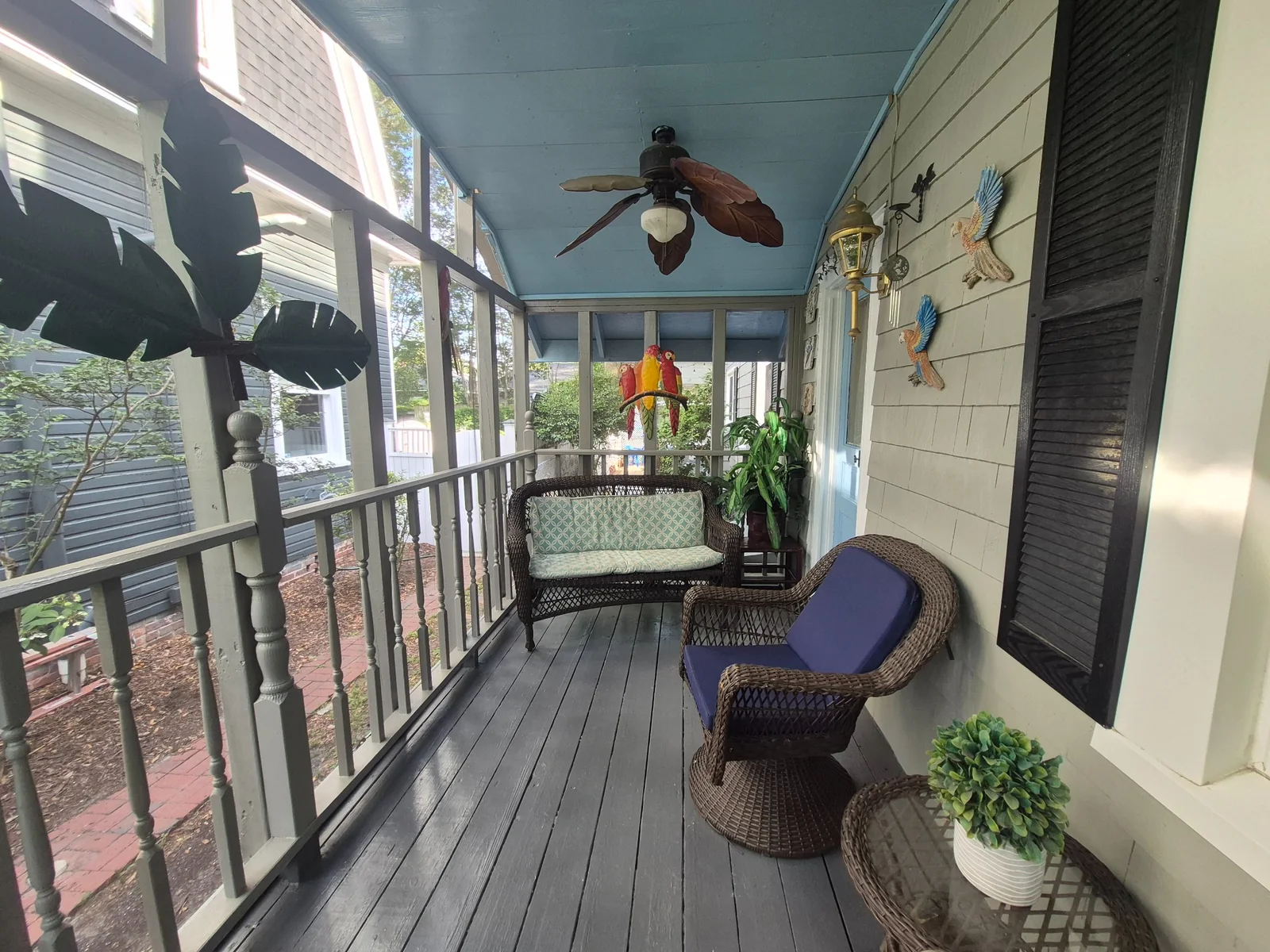 Covered side porch with wicker seating at the historic Wilmington vacation home